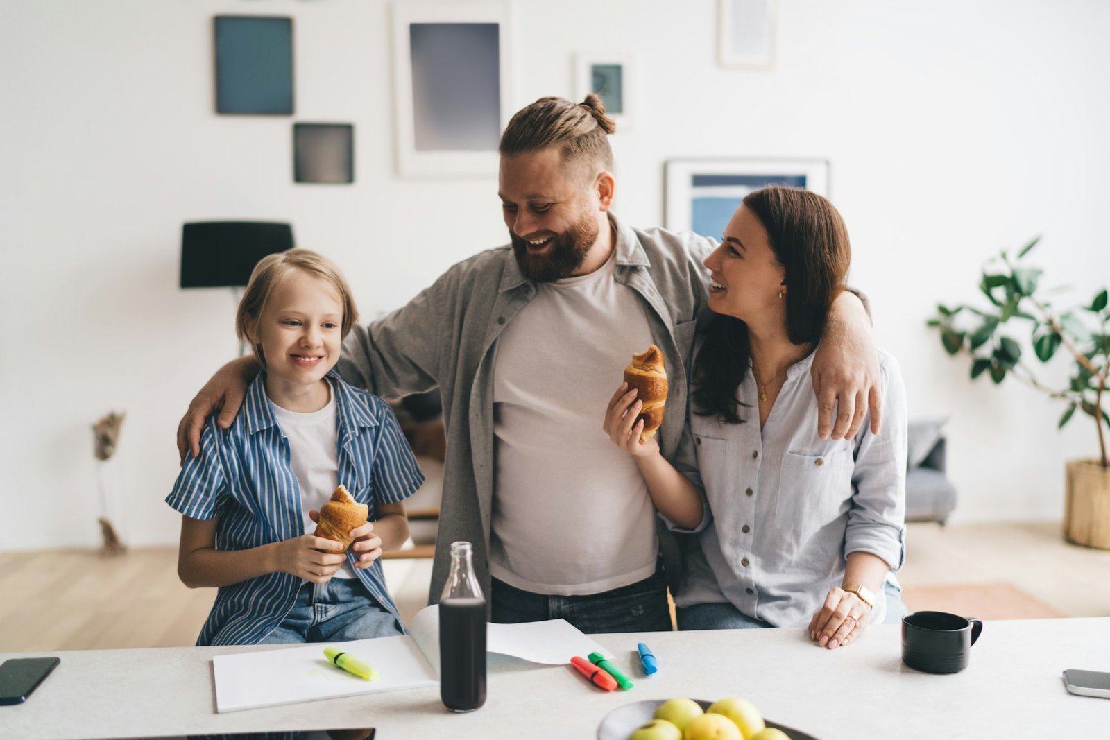 Cheerful family eating croissants for breakfast together